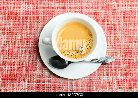 Cup of coffee on red textile, top view Stock Photo