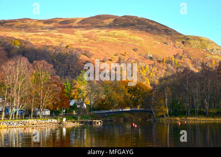 Looking across Loch Earn to St Fillans village, Scotland UK  Autumn colours and reflections clear blue sky sunny day October 2017 Stock Photo