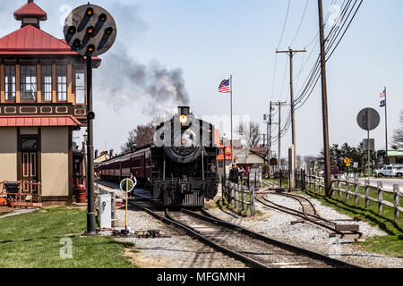 Strasburg, PA, USA - April 14, 2018:  A smokey steam locomotive operated by the Strasburg Rail Road pulls into the train station in Lancaster County,  Stock Photo