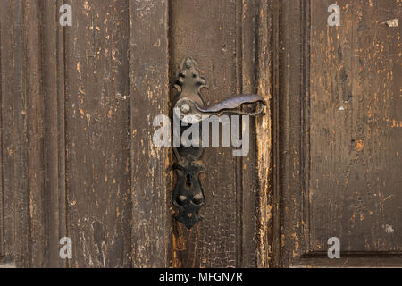 Antique metal door handle on old wooden doors. Vintage iron door knob.