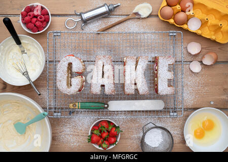 Victoria raspberry and strawberry cream sponge cakes spelling the word CAKE with ingredients from above. Pattern Stock Photo