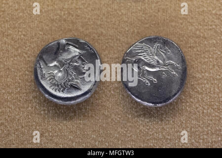 Athena and Pegasus depicted in the Ancient Greek silver coins (Corinthian stater) dated from the second half of the 4th century BC found in Sicily on display in the National Archaeological Museum (Museo Archeologico Nazionale di Napoli) in Naples, Campania, Italy. Athena is depicted wearing the Corinthian helmet. Stock Photo