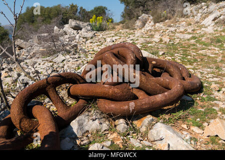 Big old rusty anchor chain lying on the ground, Croatia Stock Photo