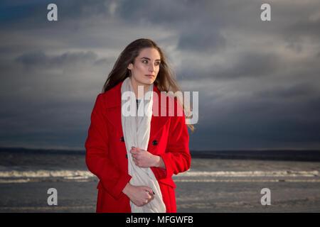 Woman in red jacket on a beach. Stock Photo