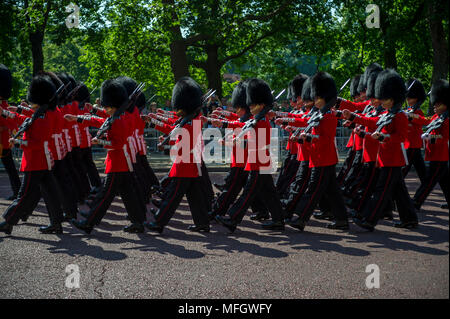 LONDON - JUNE 17, 2017: Royal guards in traditional red coats and bear fur busby hats march in formation on the Mall in a Trooping the Colour parade o Stock Photo