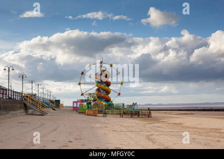 A small funfair attraction shut and closed on a beach landscape in cloudy weather in Cleethorpes, Lincolnshire. Stock Photo