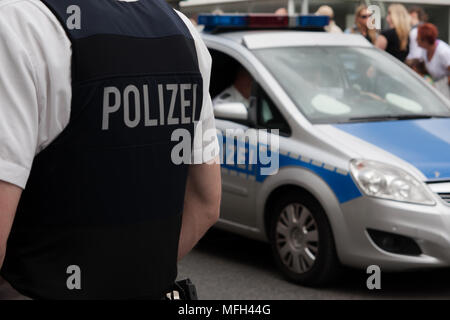 German police officer in front of a crowd Stock Photo