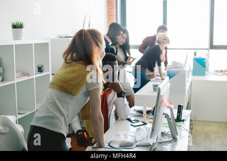 closeup side view shot of professional IT specialists doing their job in the modern office with panorama window Stock Photo