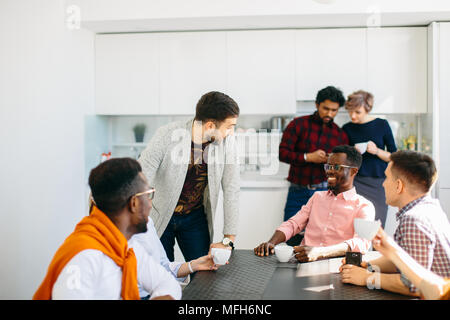 friendly conversation among diverse office workers over a cup of tea Stock Photo