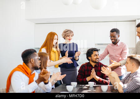 closeup shot of happy staff members greeting new CEO in informal surrounding Stock Photo