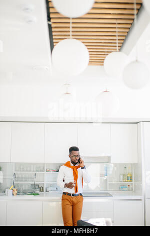 portrait of african student standing with mobile phone in modern canteen Stock Photo