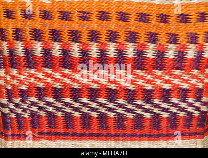 basket weave background pattern in orange, purple, red and natural brown tan. Stock Photo