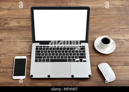 Laptop with blank screen, computer mouse, smartphone and cup of coffee on wooden table, top view Stock Photo