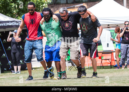 Men move in unison as they take part in a five-legged race, one of many kid's games played at Atlanta Field Day on July 16, 2016 in Atlanta, GA. Stock Photo