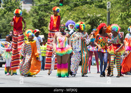 People wearing colorful clown costumes and walking on stilts participate in a parade celebrating Caribbean culture on May 28, 2016 in Atlanta, GA. Stock Photo