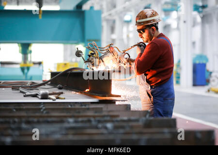 26 April 2018, Hamburg, Germany: Ramazan Solmaz, machine operator, works with the 'Kadett' autogenous plasma cutting unit in the modernized and refurbished shipbuilding hall 2 at the Blohm   Voss shipyard. Just over one and a half years after the acquisition of Blohm   Voss by the Bremer Lürssen Group, the traditional Hamburg shipyard is on a new course. Photo: Christian Charisius/dpa Stock Photo