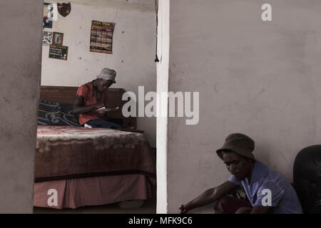 January 12, 2018 - Matatiele, Eastern Cape, South Africa - Jake, 23, sits on his bed and smokes cannabis. He says: 'I have nothing to do all day. I have finished school, but for what? There are no jobs. I am bored, and if I stay at home all day I would become crazy. To keep myself busy I wake up in the morning, then go to town and push people's trollies outside the Spar supermarket. Then I come back home to the village and sell cannabis, and hang out with my friends. I want to find a job and do something meaningful with my life. But there is nothing. You have to be very lucky to find a job aro Stock Photo