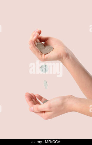 coins falling into a hand on white background Stock Photo - Alamy