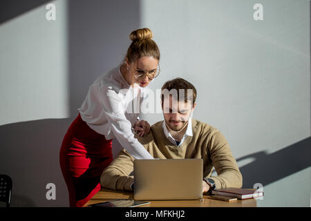 Female boss check work of her worker with laptop Stock Photo