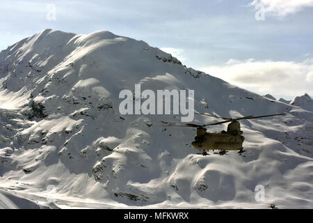 A CH-47F Chinook helicopter from B Company, 1st Battalion, 52nd Aviation Regiment flies through the Alaska Range April 22, 2018. Aviators from the Sugar Bears provided an assist to the National Park Service by flying thousands of pounds of equipment and supplies from Talkeetna to the NPS base camp at the 7,000-foot level of the Kahiltna Glacier in preparation for the 2018 Denali climbing season. (Army photo/John Pennell) Stock Photo