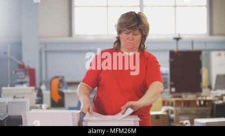Female workers sorting a paper stacks in the typography Stock Photo