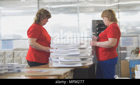Female workers sorting a paper stacks in the typography Stock Photo