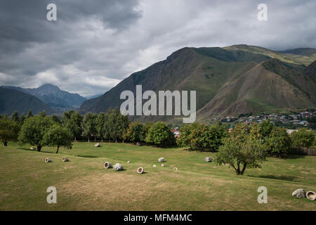 Beautiful landscape of meadows and fields, majestic mountains, clouds and sky. View from the hill on village in the green valley Stock Photo