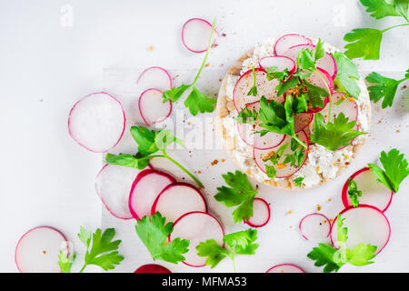 Healthy snack with crisp bread, radish slices, parsley, cottage cheese and pepper. Easy breakfast concept in high key with copy space. Stock Photo