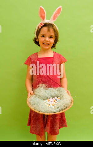 Portrait of girl holding an easter basket filled with chocolate eggs   Ref:   Compulsory Credit: Stock Photo