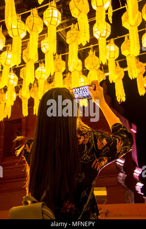 Female tourist taking picture of Northern Thai traditional lanterns with mobile smart phone Stock Photo