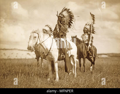 Three Native American chiefs mounted on horses and wearing feather headdresses.  Photograph c1890. Stock Photo