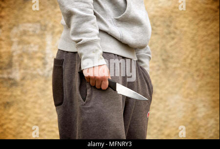 PICTURE POSED BY MODEL. A youth with a knife. Police recorded 39,598 offences involving a knife or sharp instrument in the latest year ending December 2017, a 22% increase compared with the previous year (32,468), and the highest number registered since comparable records started in 2010. Stock Photo