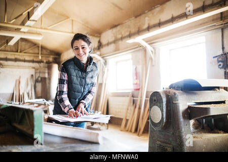 Portrait of a woman worker in the carpentry workshop. Stock Photo