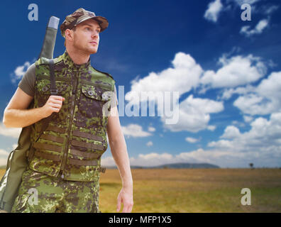 young soldier or hunter with gun over savannah Stock Photo