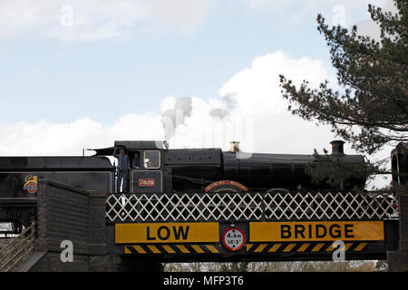 Gloucestershire and Warwickshire Steam Railway collection. Steam train on a low bridge. Stock Photo