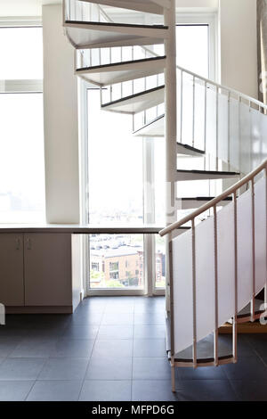 Spiral staircase leading up from modern kitchen, New York, USA Stock Photo