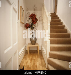 View from the bottom of stairs facing decorative red flowers and stairs to the right Stock Photo