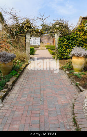 Brick paved path and archway leading from the sundial garden to the flower garden and citrus greenhouse in the Lost Gardens of Heligan Cornwall Stock Photo