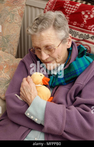 Elderly woman wearing a fleece jacket & a warm scarf in winter model release Stock Photo