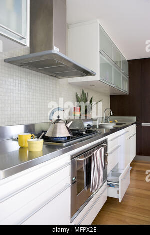 Gas hob set in worktop in modern kitchen with white units Stock Photo