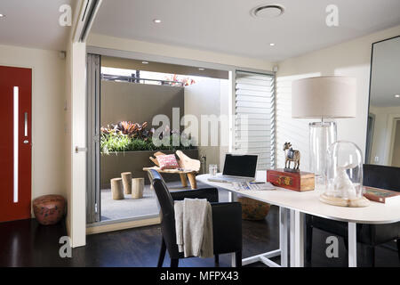 Lap top computer on table in modern room with view through patio doors Stock Photo