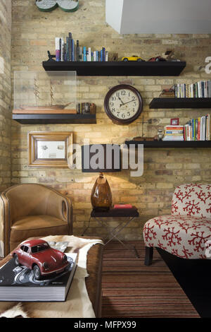 Shelving on brick wall in modern sitting room Stock Photo