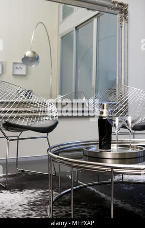 Steel coffee table in front of pair of Harry Bertoia chairs in modern sitting room Stock Photo