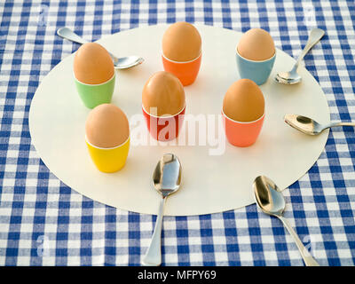 Boiled eggs in colourful egg cups Stock Photo