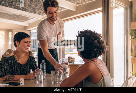 Little break. Handsome young men in sportswear holding water bottle and  looking at camera with smile while sitting at gym 13556699 Stock Photo at  Vecteezy