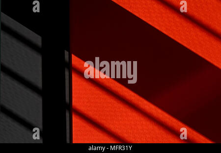 Diagonal shadow stripes on red and black wall Stock Photo