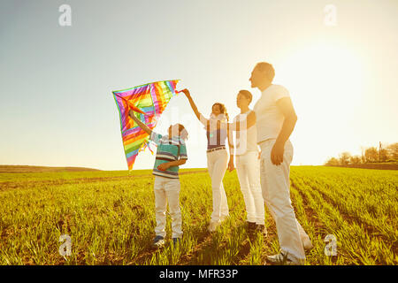 Happy family playing with a kite on nature in spring, summer. Stock Photo