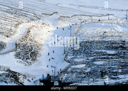 Skiers in February adjacent to the funicular railway, linking base station to Ptarmigan station at the top of Cairngorm, Britain's 6th highest mountai Stock Photo