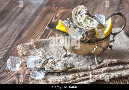 Raw oysters in the gravy boat Stock Photo