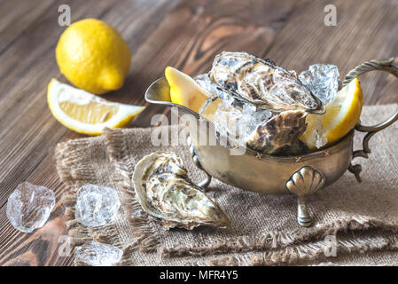 Raw oysters in the gravy boat Stock Photo